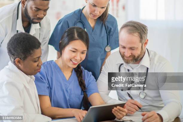 doctors working together - resident stock pictures, royalty-free photos & images