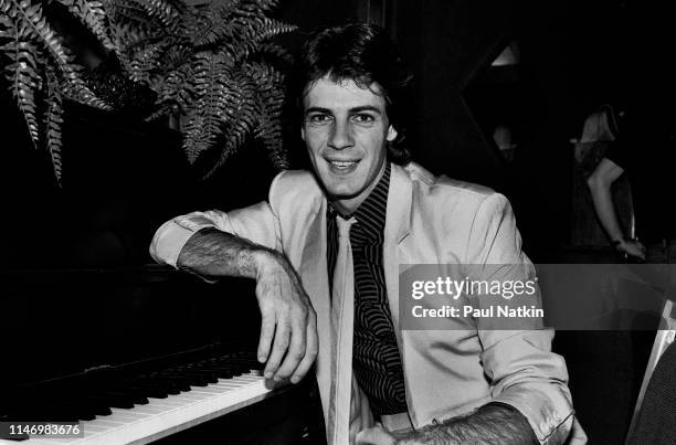 Portrait of American Rock musician Rick Springfield as he leans on a piano, backstage at the Mill Run Theater, Niles, Illinois, September 6, 1981.