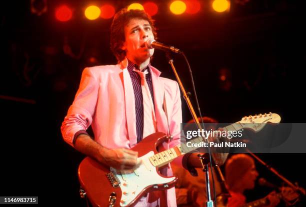 American Rock musician Rick Springfield plays guitar as he performs onstage at the Mill Run Theater, Niles, Illinois, September 6, 1981.