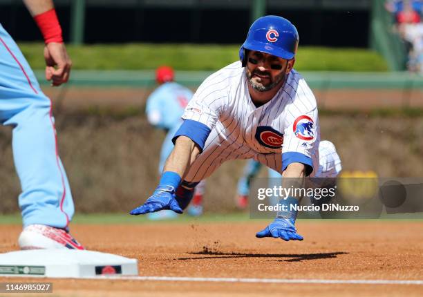 Daniel Descalso of the Chicago Cubs slides safely into third base on an error during the first inning of a game by Dexter Fowler of the St. Louis...