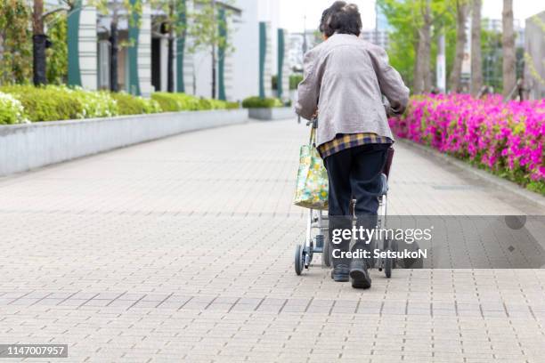 elderly person with walking auxiliary instrument. - senior women shopping stock pictures, royalty-free photos & images