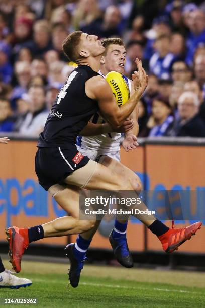 Cameron Zurhaar of the Kangaroos collides into Liam Jones of the Blues during the round seven AFL match between the Carlton Blues and the North...