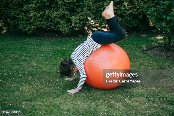 playing fitness bouncing ball outdoors - gymnastikball stock-fotos und bilder