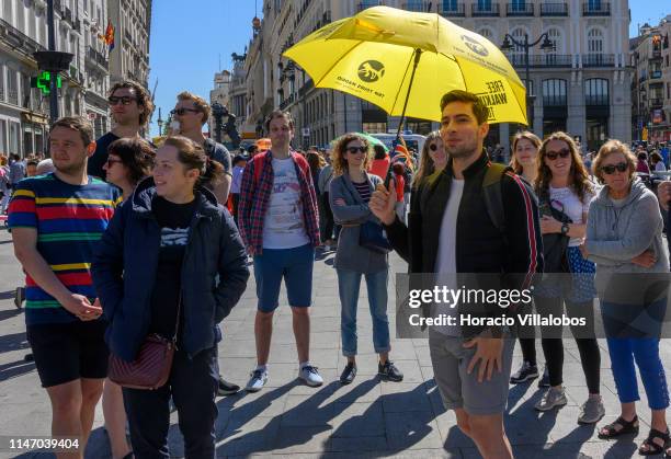 Tour guide displays an umbrella while briefing visitors during a free walking city tours in Puerta del Sol square on May 04, 2019 in Madrid, Spain....