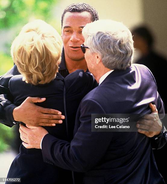 Cowling, a friend of O.J. Simpson, hugs attendees as he departs the funeral for Simpson's ex-wife Nicole Brown Simpson June 16, 1994