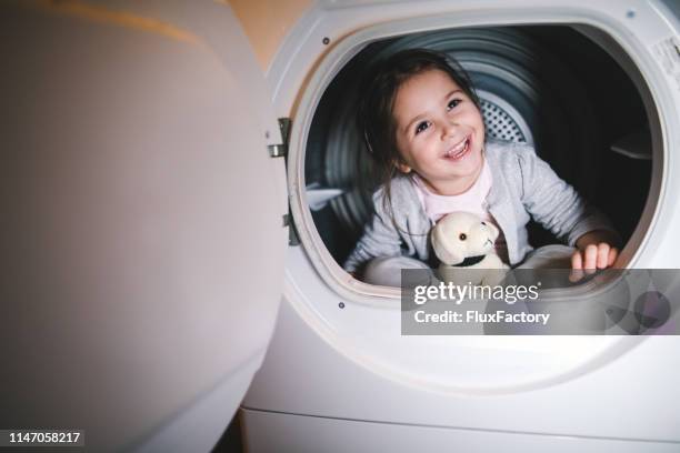 cheerful smiling child enjoying her time at home having fun - dog washing machine stock pictures, royalty-free photos & images