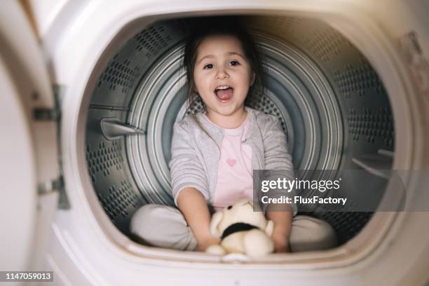 innocent and carefree child playing in a washing machine - dog washing machine stock pictures, royalty-free photos & images