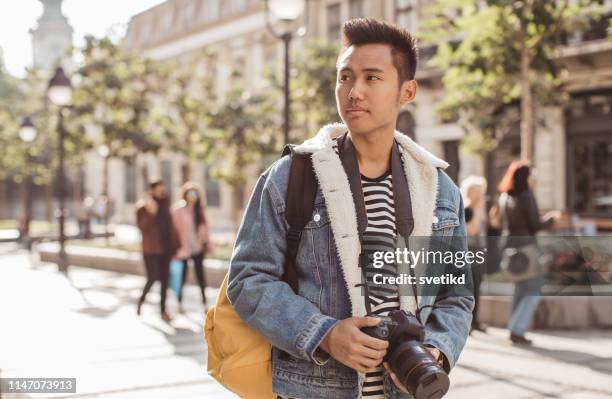 tourist taking photo on city street - vietnamese ethnicity stock pictures, royalty-free photos & images