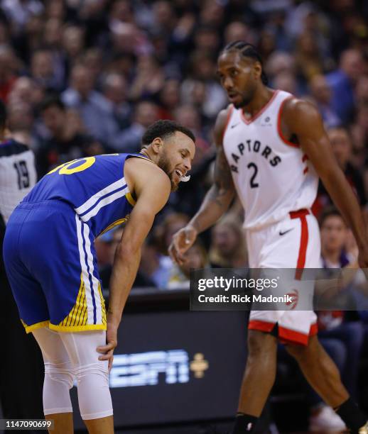 Golden State Warriors guard Stephen Curry after losing a ball for a turn over and as Toronto Raptors forward Kawhi Leonard walks to the bench for a...