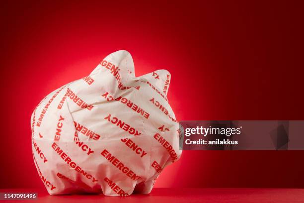 piggy bank verpakt met nood papier - bord-in-geval-van-nood stockfoto's en -beelden