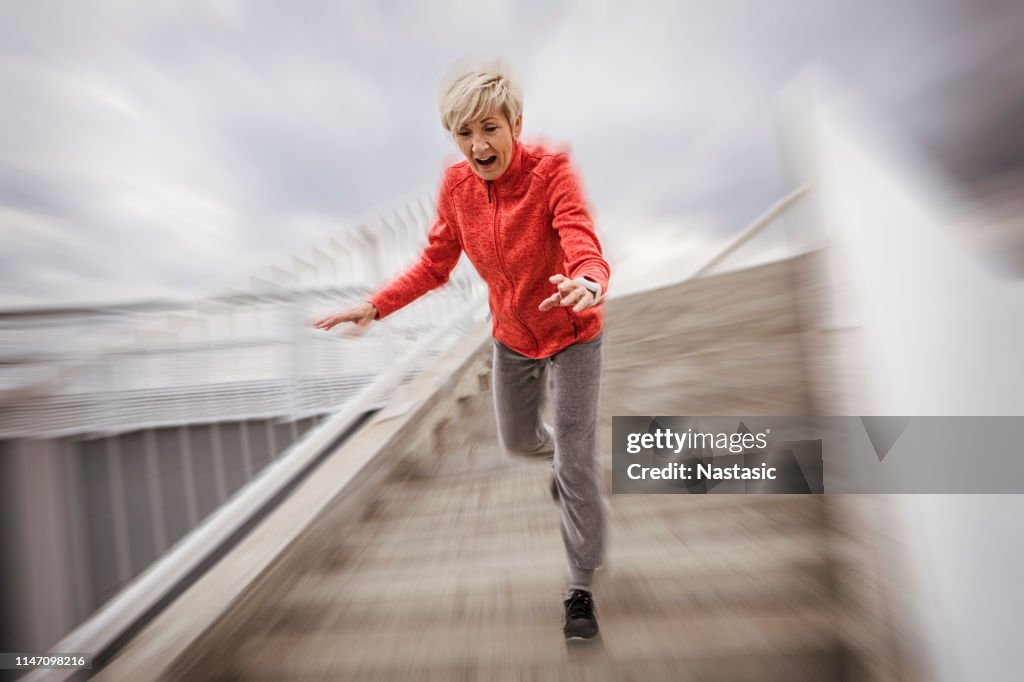 Mujer mayor cayendo escalones de piedra al aire libre