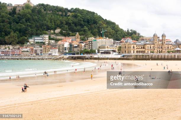la concha beach in san sebastian with people on the beach - san sebastian spain beach stock pictures, royalty-free photos & images