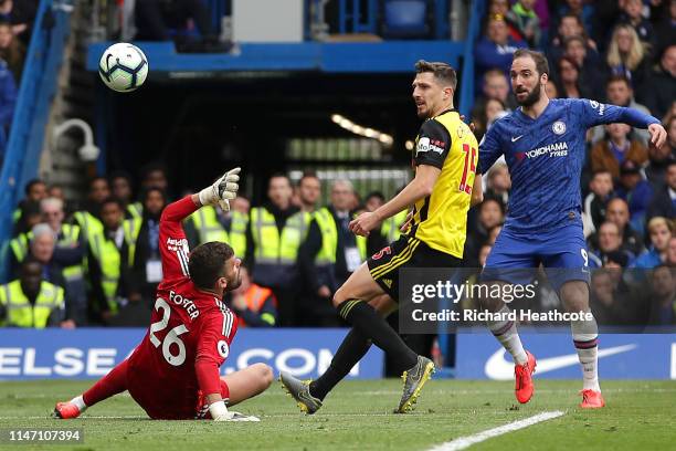 Gonzalo Higuain of Chelsea beats Ben Foster and Craig Cathcart of Watford as he scores his team's third goal during the Premier League match between...