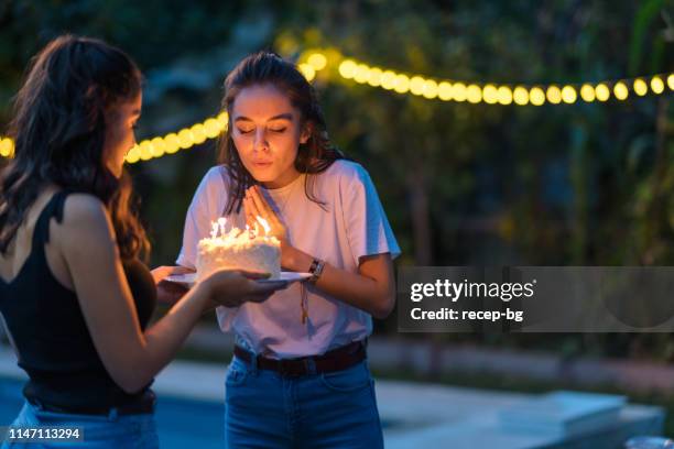 twee vrouwelijke vrienden vieren verjaardagsfeestje - wensen stockfoto's en -beelden