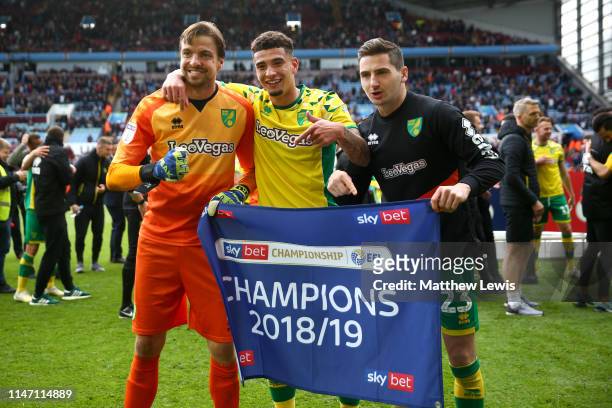 Tim Krul, Ben Godfrey and Kenny McLean of Norwich City celebrate winning the title after the Sky Bet Championship match between Aston Villa and...