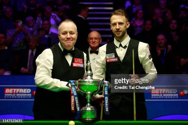 John Higgins of Scotland shakes hands with Judd Trump of England prior to their final match on day 16 of the 2019 Betfred World Snooker Championship...