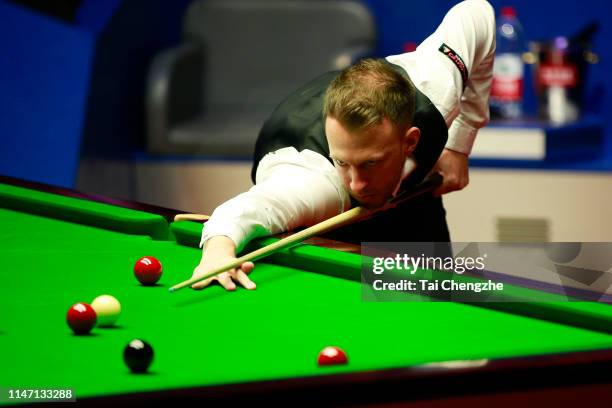 Judd Trump of England plays a shot in the final match against John Higgins of Scotland on day 16 of the 2019 Betfred World Snooker Championship at...