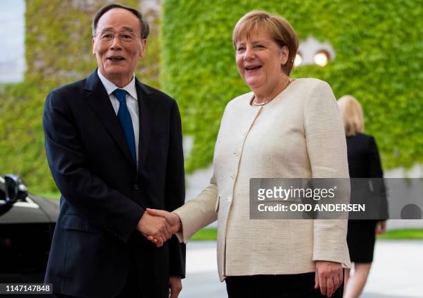 German Chancellor Angela Merkel greets Chinese Vice President Wang Qishan on his arrival prior to a meeting at the Chancellery in Berlin on May 31,...