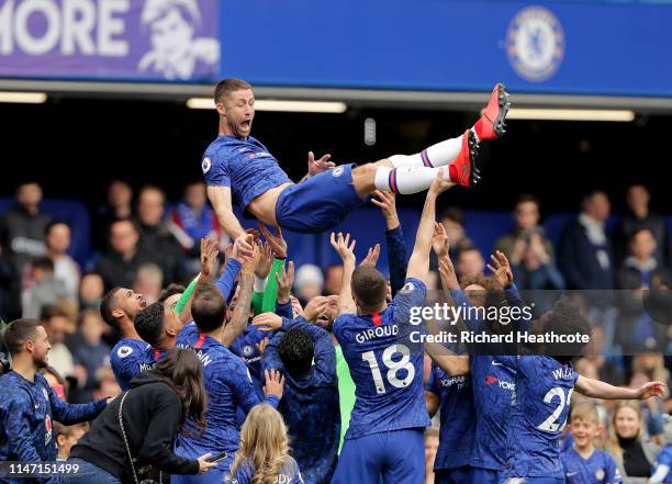 Gary Cahill of Chelsea is thrown up in the air by his team mates after the final whistle during the Premier League match between Chelsea FC and...