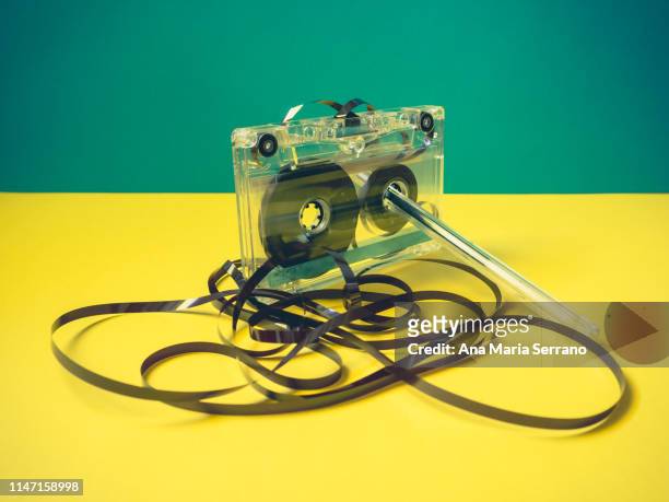 single audio cassette tape with loose tape spilling from top cassette and a pen on vintage style - audiocassette stock-fotos und bilder
