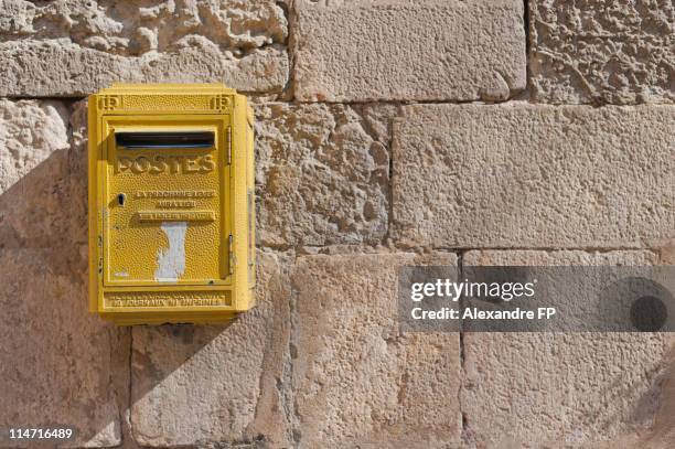 french yellow "postes" letter box on stone wall - ranura de buzón fotografías e imágenes de stock