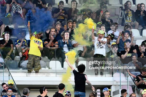 Fans cheer and light flare bombs during the second free practice session for the Italian Moto GP Grand Prix at the Mugello race track on May 31, 2019...