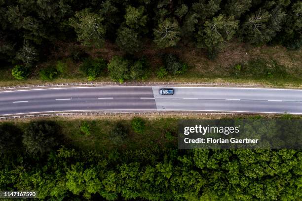 This aerial photograph shows a car driving on a country road on May 31, 2019 in Zentendorf, Germany.