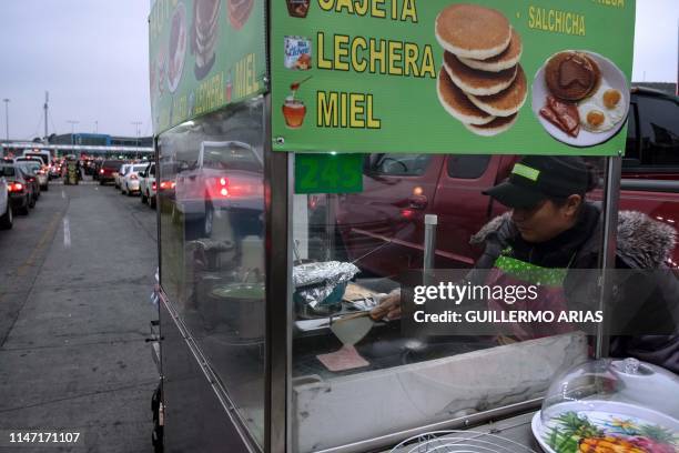 Street vendor prepares food to sell to people heading to the US at the San Ysidro border crossing, in Tijuana, Baja California State, Mexico, on May...