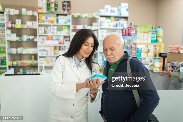 female pharmacist giving medications to senior customer - pharmacist and patient stock pictures, royalty-free photos & images