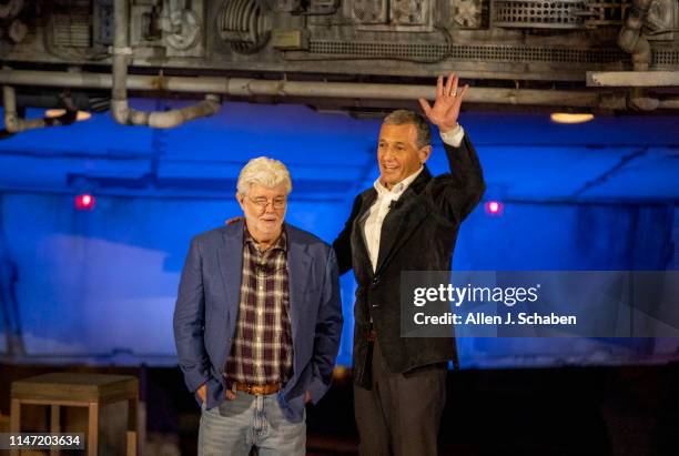 Bob Iger, right, CEO of The Walt Disney Company, waves to the crowd with George Lucas, Star Wars creator, in front of the Millennium Falcon during...