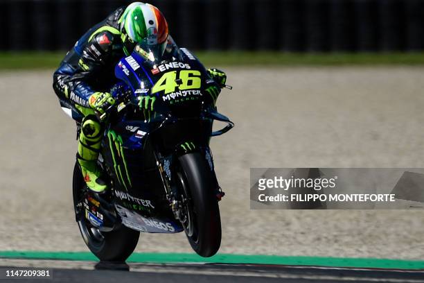 Italy's Valentino Rossi performs a wheeling as he rides his Yamaha during free practice 3 ahead the Italian Moto GP Grand Prix at the Mugello race...