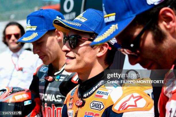 France's Fabio Quartararo, Spain's Marc Marquez and Italy's Danilo Petrucci stand in the pits after respectively placing second, first and third of...