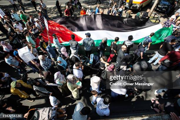 Protesters wave a large Palestinian flag during the annual Al-Quds march on June 1, 2019 in Berlin, Germany. Critics accuse the Al-Quds marchers of...
