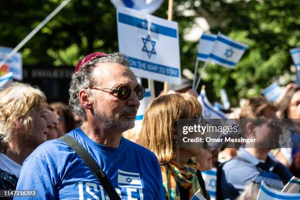 Man wearing a Kippa among other counter demonstrators wave Israeli flags as the annual Al-Quds march pass by on June 1, 2019 in Berlin, Germany....