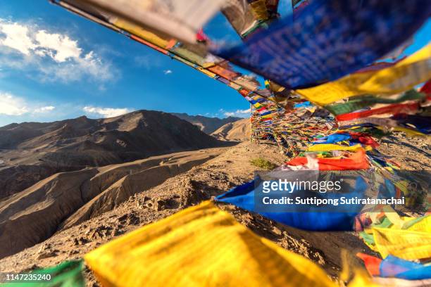 prayer flags flicking on top of mountain at lamayuru temple in leh ladakh on the hill in mountain valley with blue sky - lhasa stock-fotos und bilder