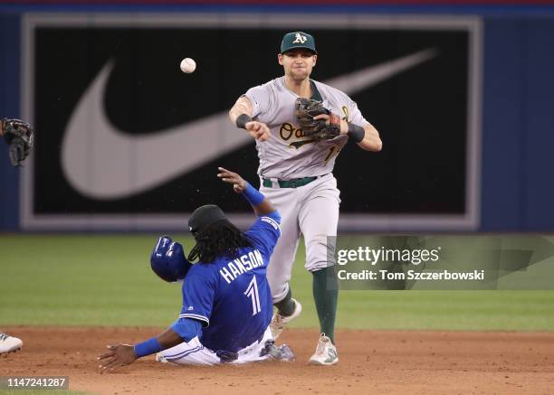 Chad Pinder of the Oakland Athletics gets the force out of Alen Hanson of the Toronto Blue Jays at second base but cannot turn the double play in the...