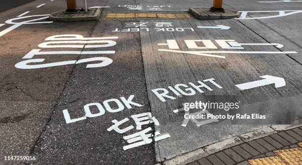 traffic signs on the ground, english and chinese languages - translation stock pictures, royalty-free photos & images