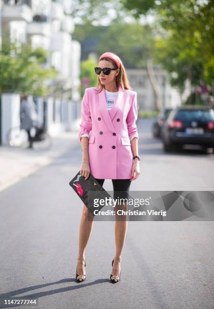 Alexandra Lapp is seen wearing a pink oversized blazer from Zara, a logo print t-shirt in black and white from Balenciaga, biker / cycling shorts...