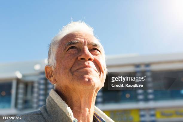 el hombre mayor sonriente mira hacia el cielo, relajado y contento - entrecerrar los ojos fotografías e imágenes de stock