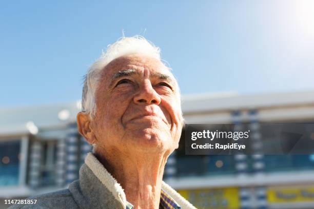 smiling senior man looks up at sky, relaxed and contented - cancer center stock pictures, royalty-free photos & images