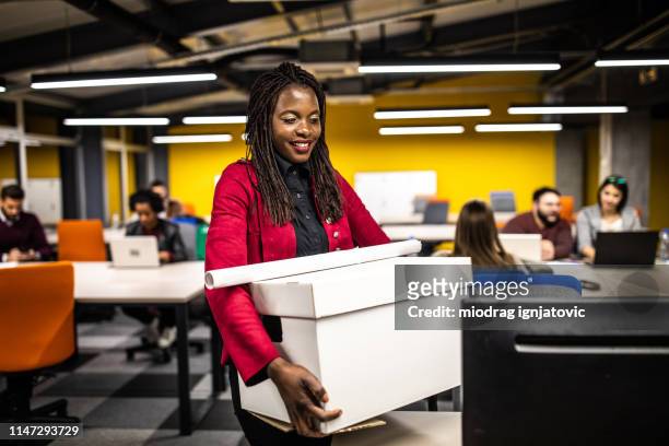 african woman carrying box at new office - day 1 stock pictures, royalty-free photos & images