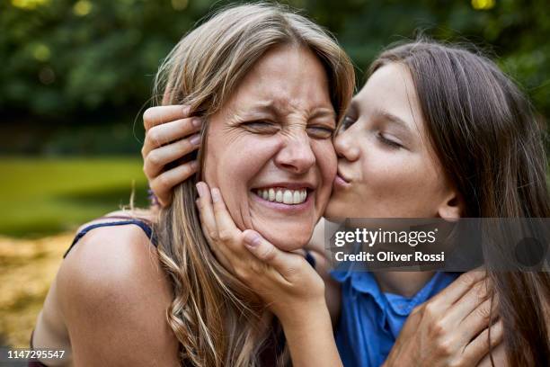 girl hugging and kissing happy mother - happy smiling family stockfoto's en -beelden