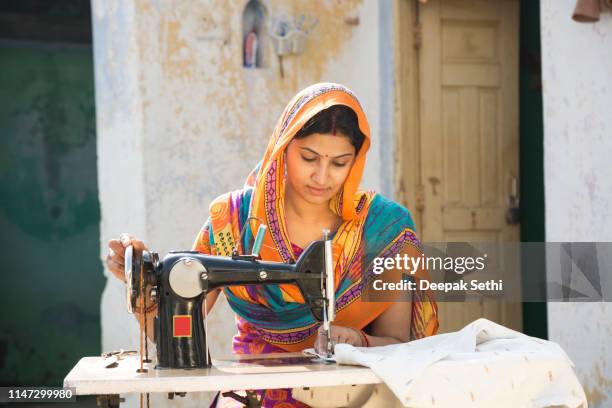 indische frauen nähen tücher maschinell zu hause-bestandsbild - frau nähen stock-fotos und bilder