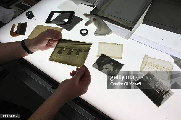 Darkroom technician Kevin Gleeson checks the quality of a glass slide from the vast collection of historic photographs in the Hulton Archive on May...