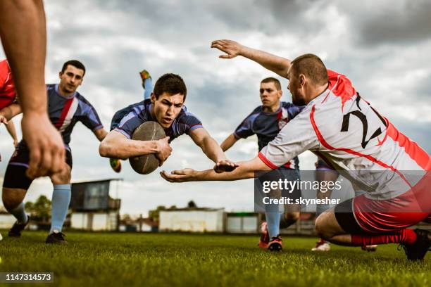 vastberaden speler scoren touchdown op een rugby wedstrijd op speelveld. - rugby union tournament stockfoto's en -beelden