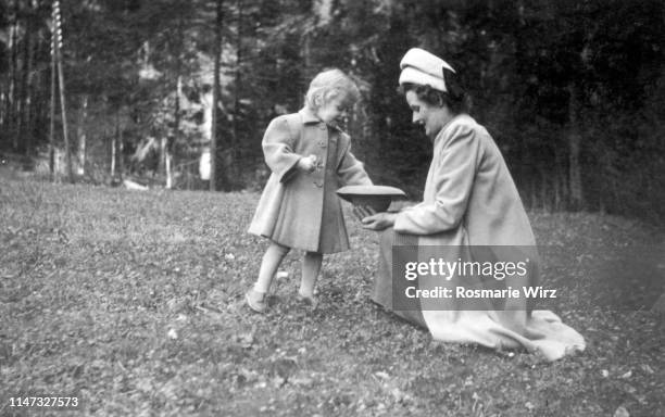 mother and daughter picking flowers - fashion archive stock-fotos und bilder