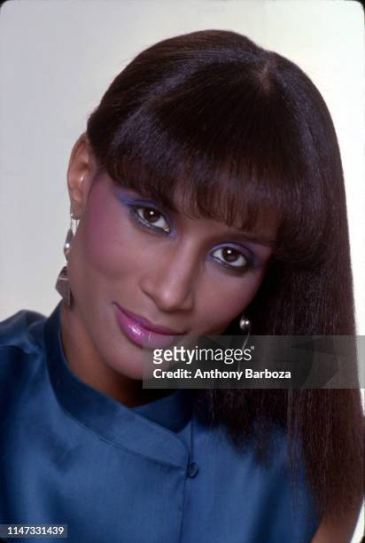 Portrait of model Beverly Johnson, in a blue top, as she poses against a white background, New York, 1980s.