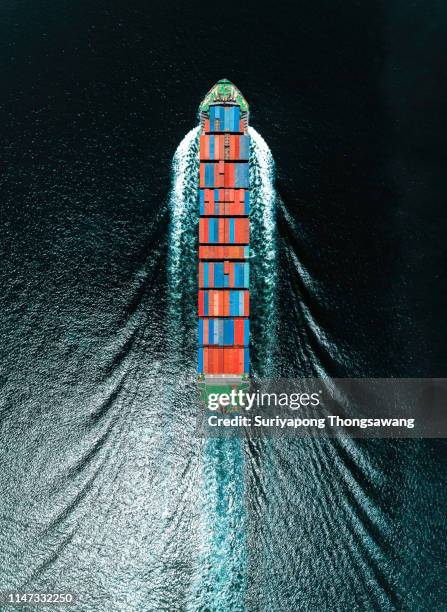 aerial top view container ship on deep sea full speed with beautiful wave pattern for logistics, import export, shipping or transportation. - ship above stock pictures, royalty-free photos & images