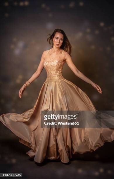 portrait of young woman wearing golden evening dress - gold dress 個照片及圖片檔