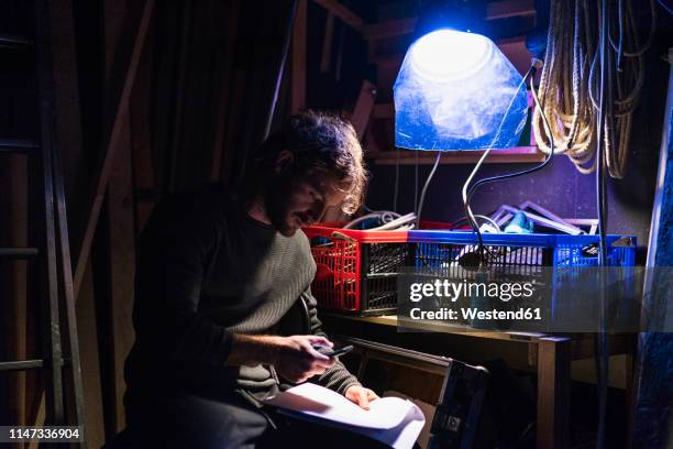 man with script sitting backstage at theatre looking at cell phone - roadie stock pictures, royalty-free photos & images